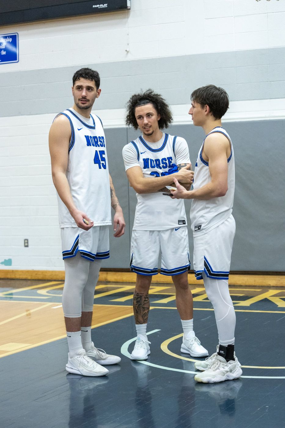 Kyanu talking with two teammates on court