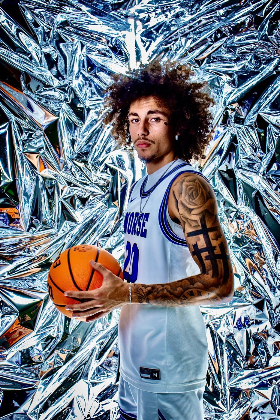 Kyanu Simeone holding a basketball, portrait on a silver foil backdrop
